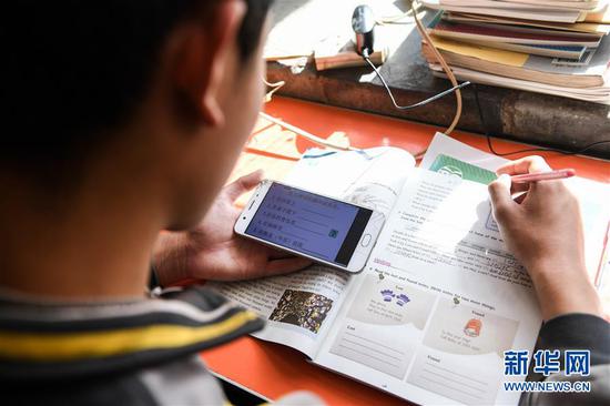  3月10日，內(nèi)蒙古準格爾旗龍口鎮(zhèn)紅樹梁村的初一學生劉進才在家中上網(wǎng)課。&nbsp;新華社記者 劉磊 攝