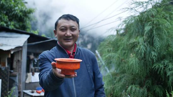  扎西巴珠展示他制作的木碗。新華網(wǎng) 旦增努布攝